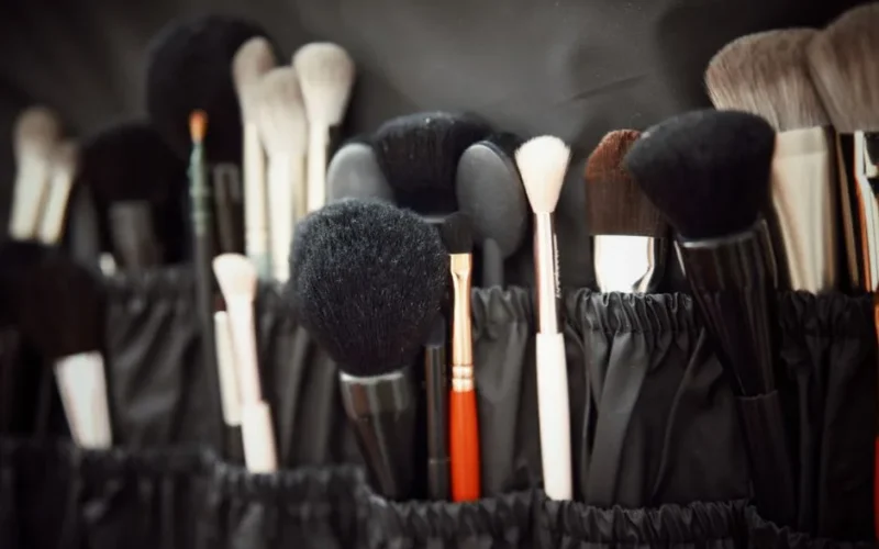 A collection of various makeup brushes neatly arranged in a black holder, ideal for beauty enthusiasts.