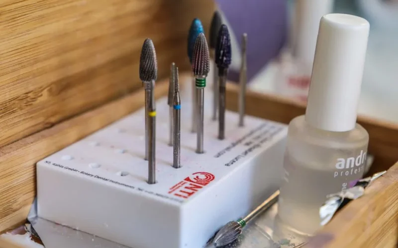 Detailed view of manicure drill bits and polish for nail care.