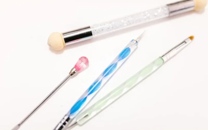 Detailed view of makeup and beauty tools including brushes on a white background.