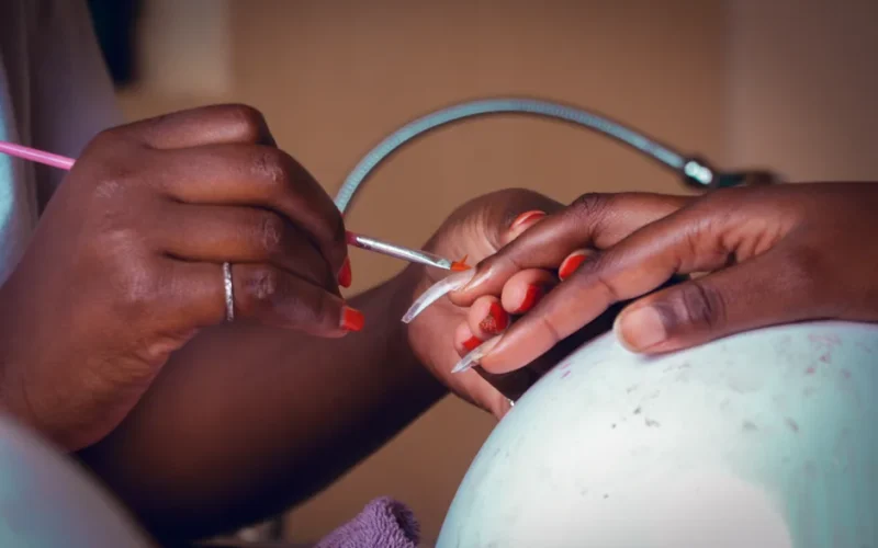 Detailed view of a nail technician applying polish during a manicure session.