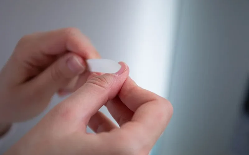 A detailed view of hands using a nail file for grooming purposes.