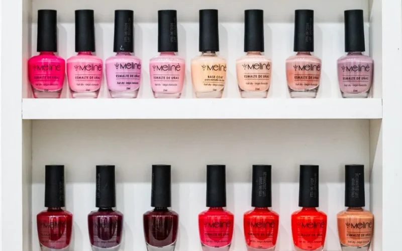 Vibrant display of nail polish in various shades on a white shelf.