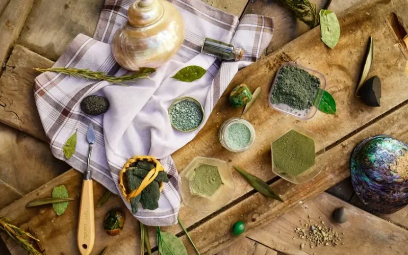 Top view of assorted natural pigments on wooden background, evoking a rustic artisanal feel.
