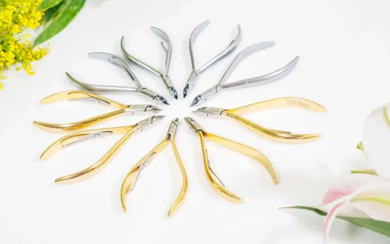 Stylish studio photo of cuticle nippers arranged in a circle with floral accents.