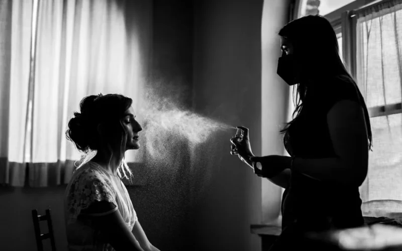 Artistic black and white photo of a beautician spraying mist in a beauty spa
