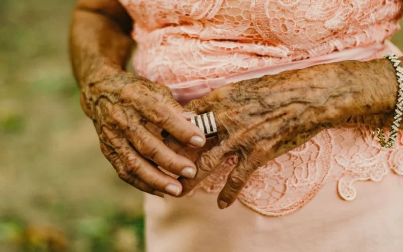 Detailed close-up of an elderly woman's hands adorned with rings and bracelets, showcasing aging beauty.