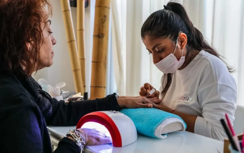 Nail technician providing a manicure service in a salon setting.