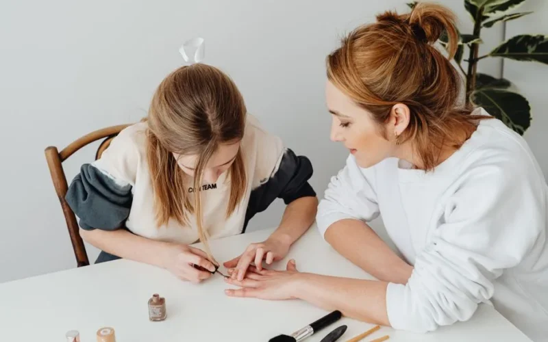 A mother and daughter bonding over a relaxing nail care session at home.